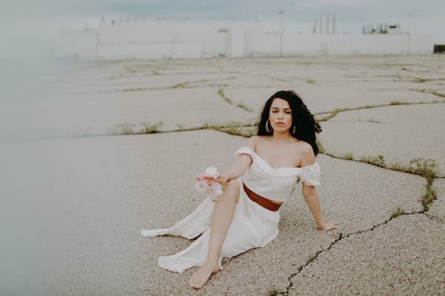 Woman in a White Dress Lying on the Ground