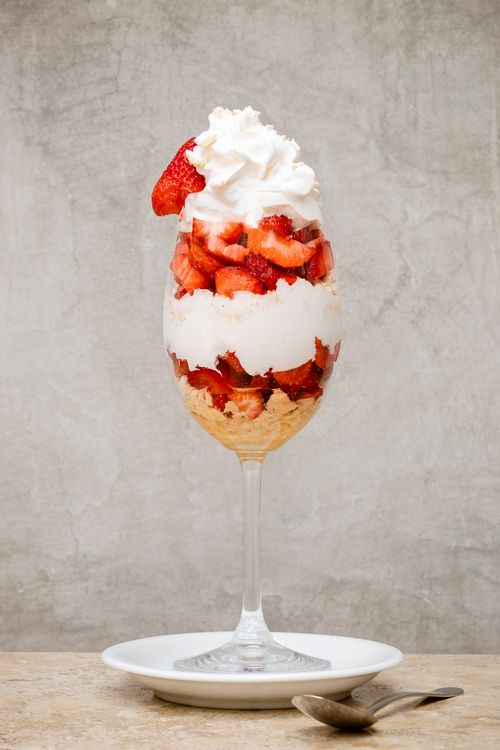Free Delicious strawberry parfait with whipped cream in a wine glass. Stock Photo