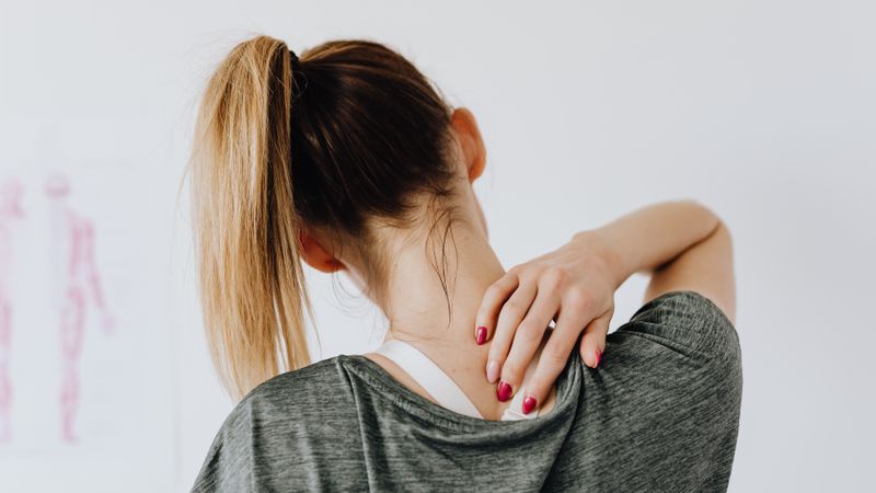 Person experiencing back pain considering CBD as a natural pain relief option