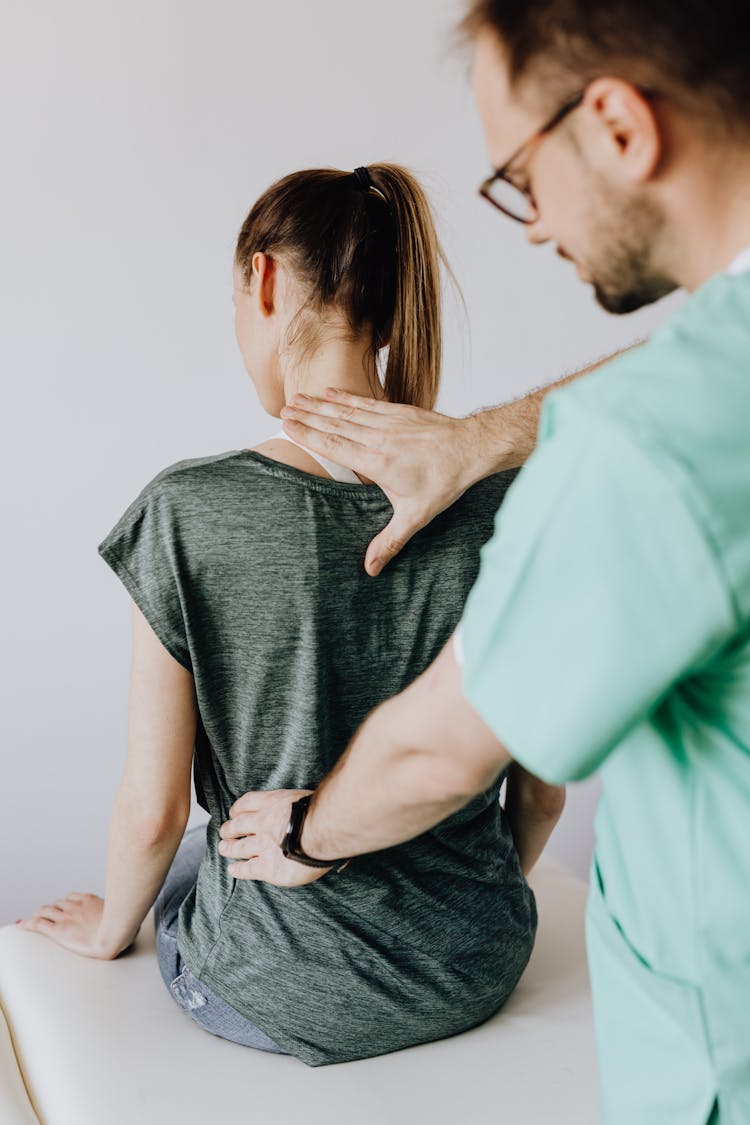 Crop Osteopath Checking Up Back Of Anonymous Patient In Hospital