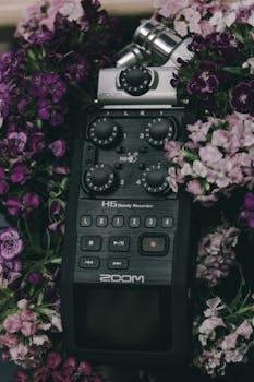 Handy audio recorder amidst vibrant purple and pink flowers, combining technology with nature.