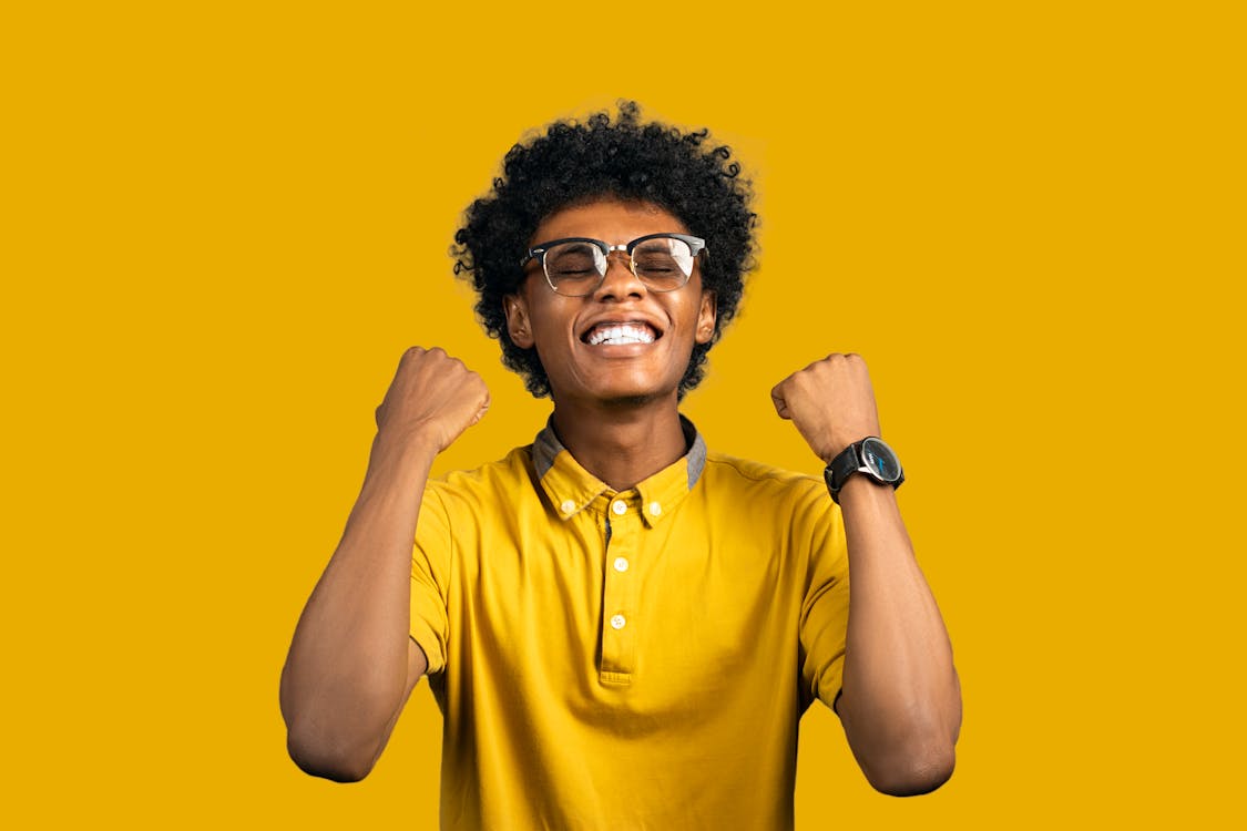 Excited African American man with accessories showing yes gesture