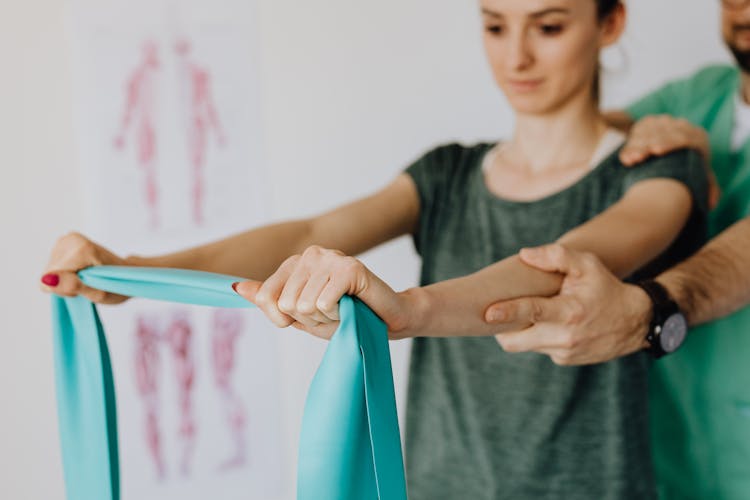 Crop Unrecognizable Chiropractor And Female Patient With Elastic Tape