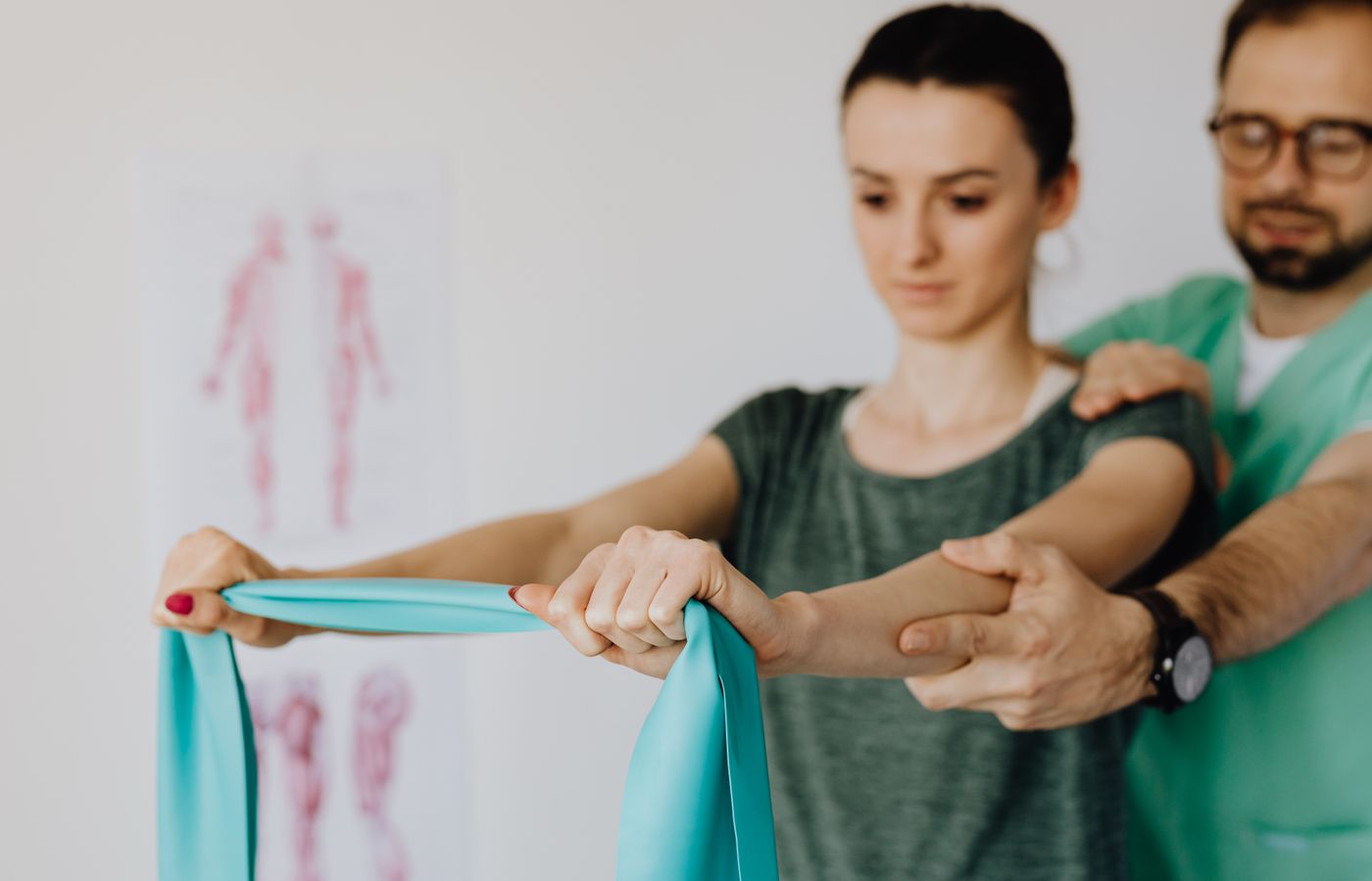 A young woman receives physical therapy assistance, using a stretching band for rehabilitation.