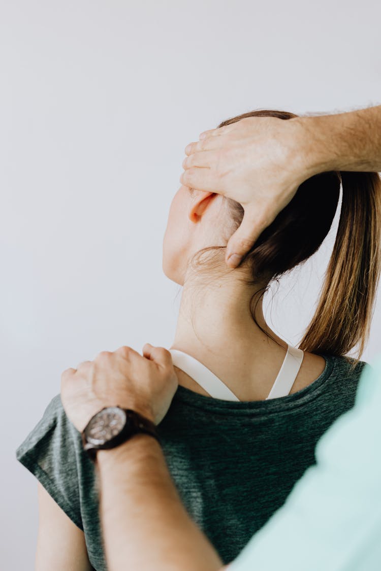 Professional Massage Therapist Treating A Female Patient's Injured Neck