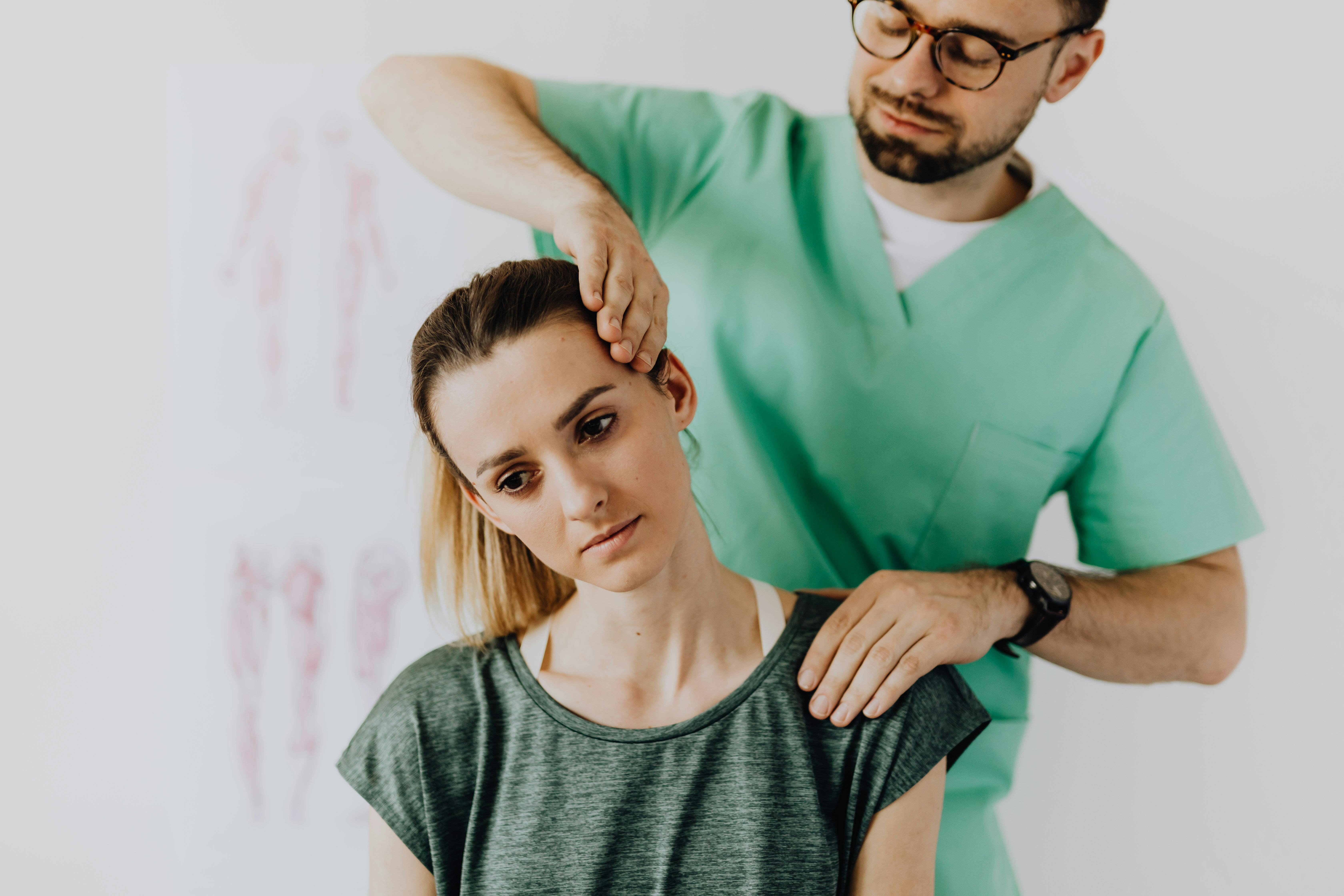 Crop chiropractor stretching neck of female patient in doctor office ...