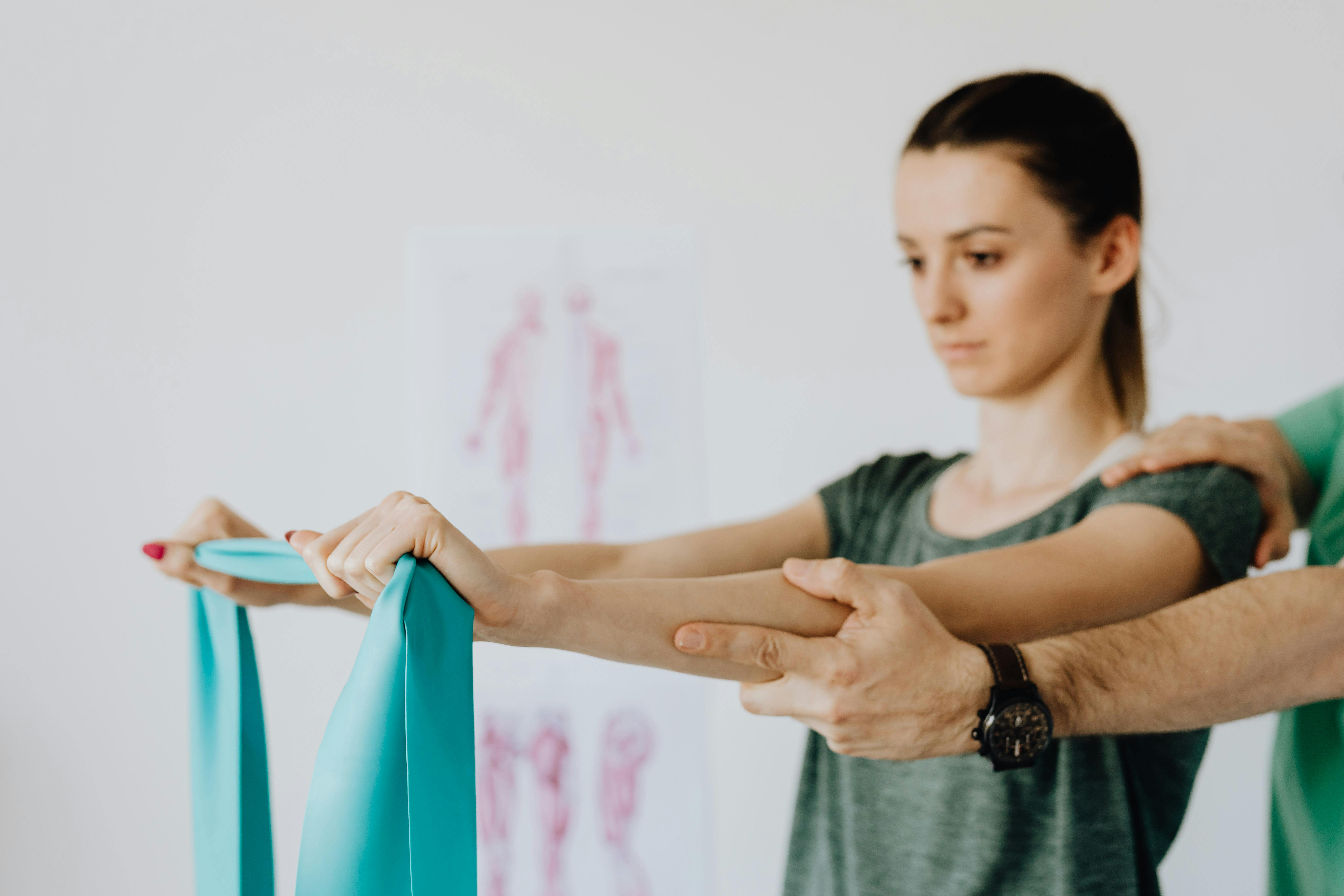 woman stretching elastic tape during medical examination by crop orthopedist