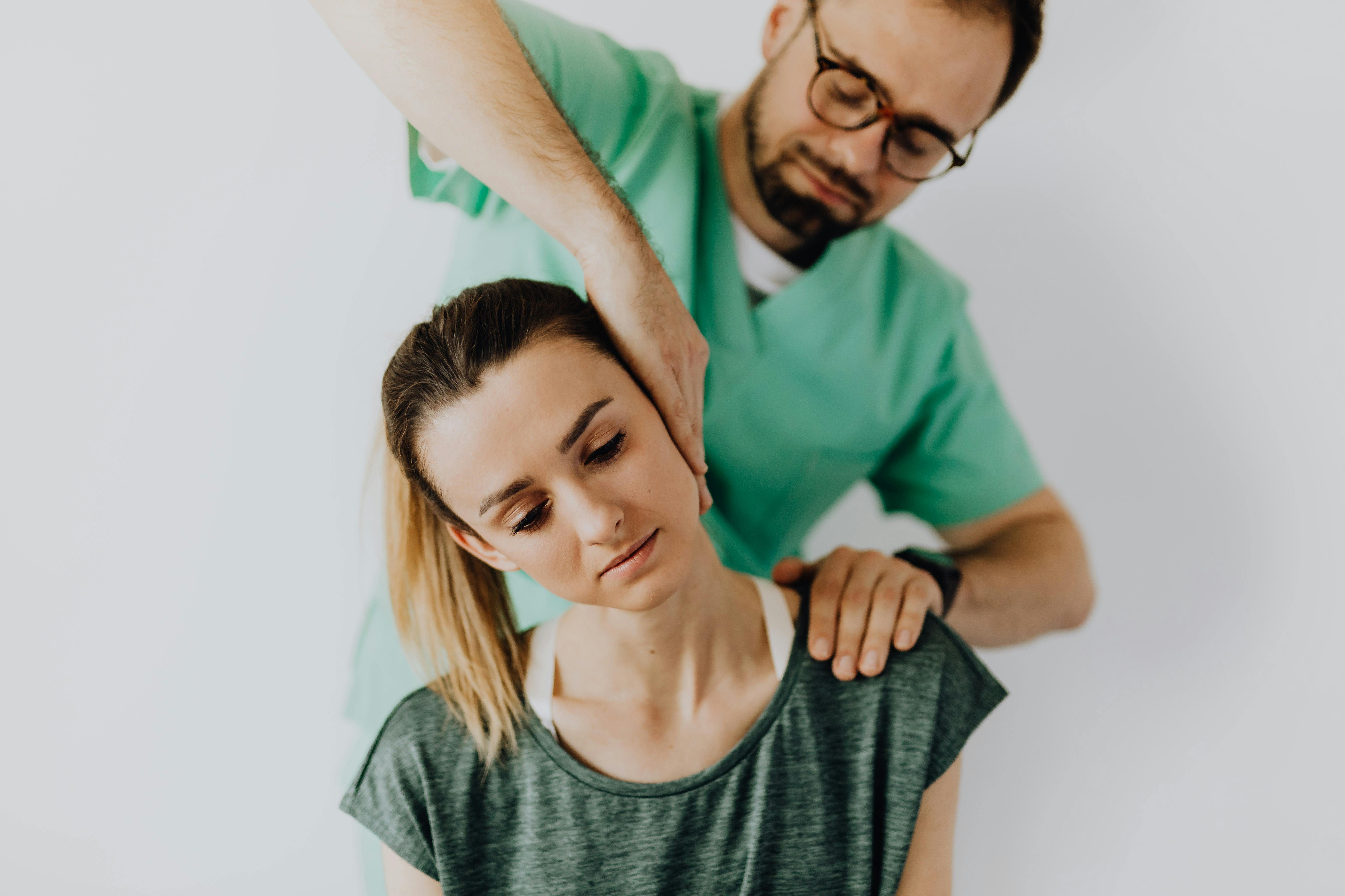 professional massage therapist treating a female patient s injured neck