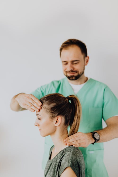 Free Professional Massage Therapist Treating a Female Patient's Injured Neck Stock Photo