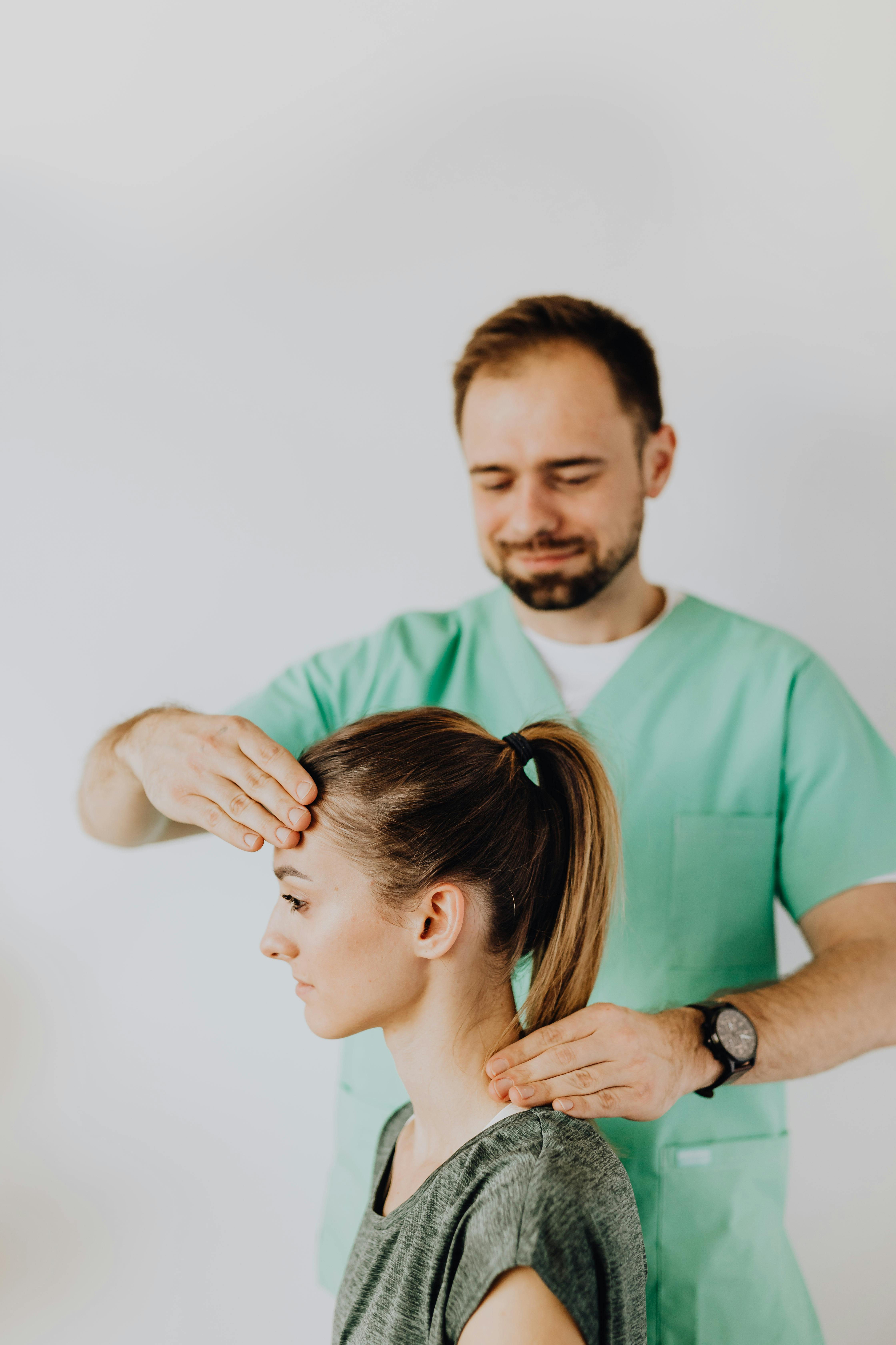 Confident Massage Therapist Doing Neck Massage For Patient · Free Stock