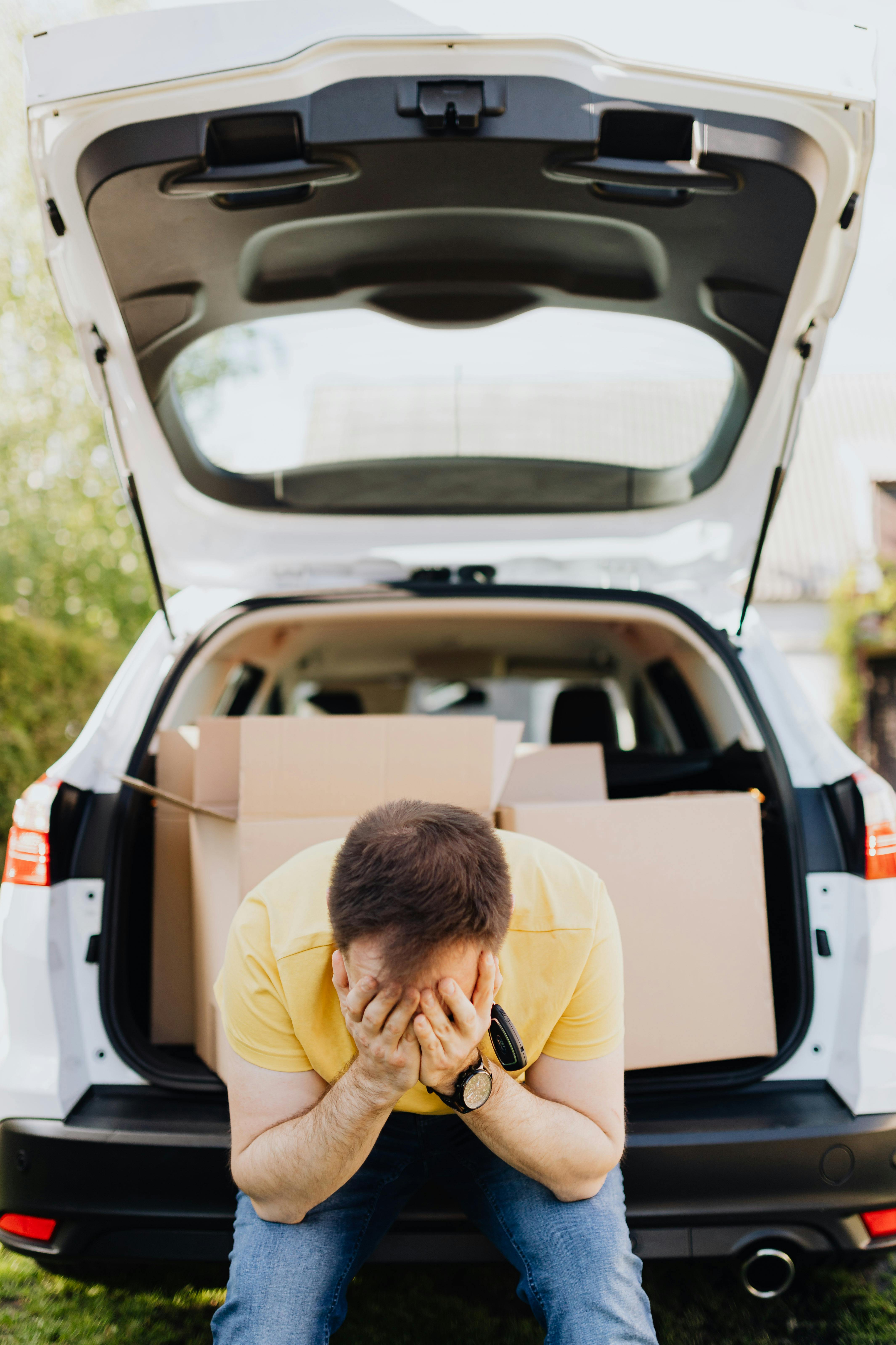 stressed man covering face while moving out