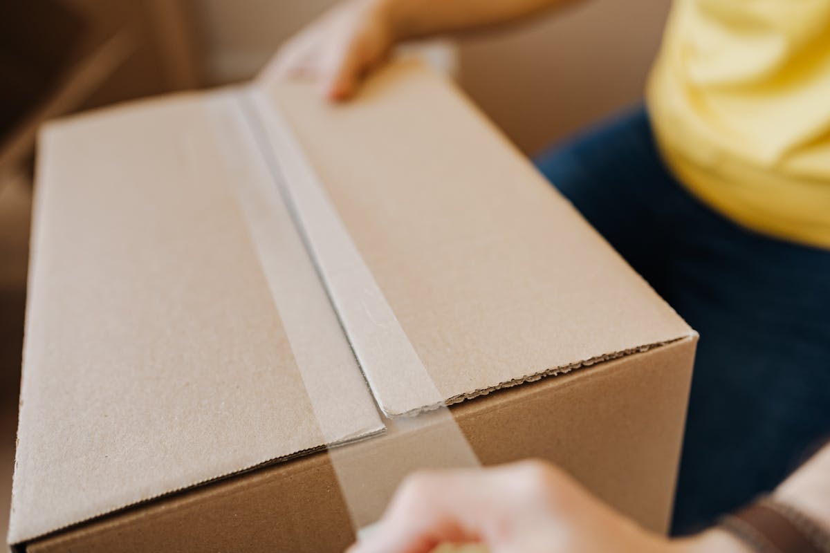 Close-up of sealing a carton with tape