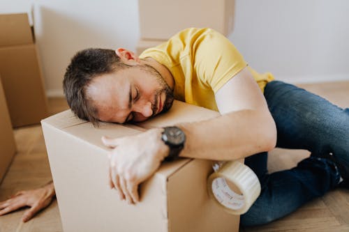 Tired man fell asleep on carton box