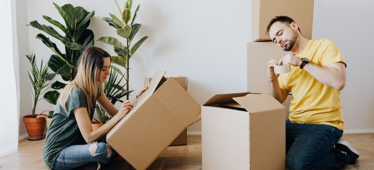 Couple packing belongings into cardboard boxes