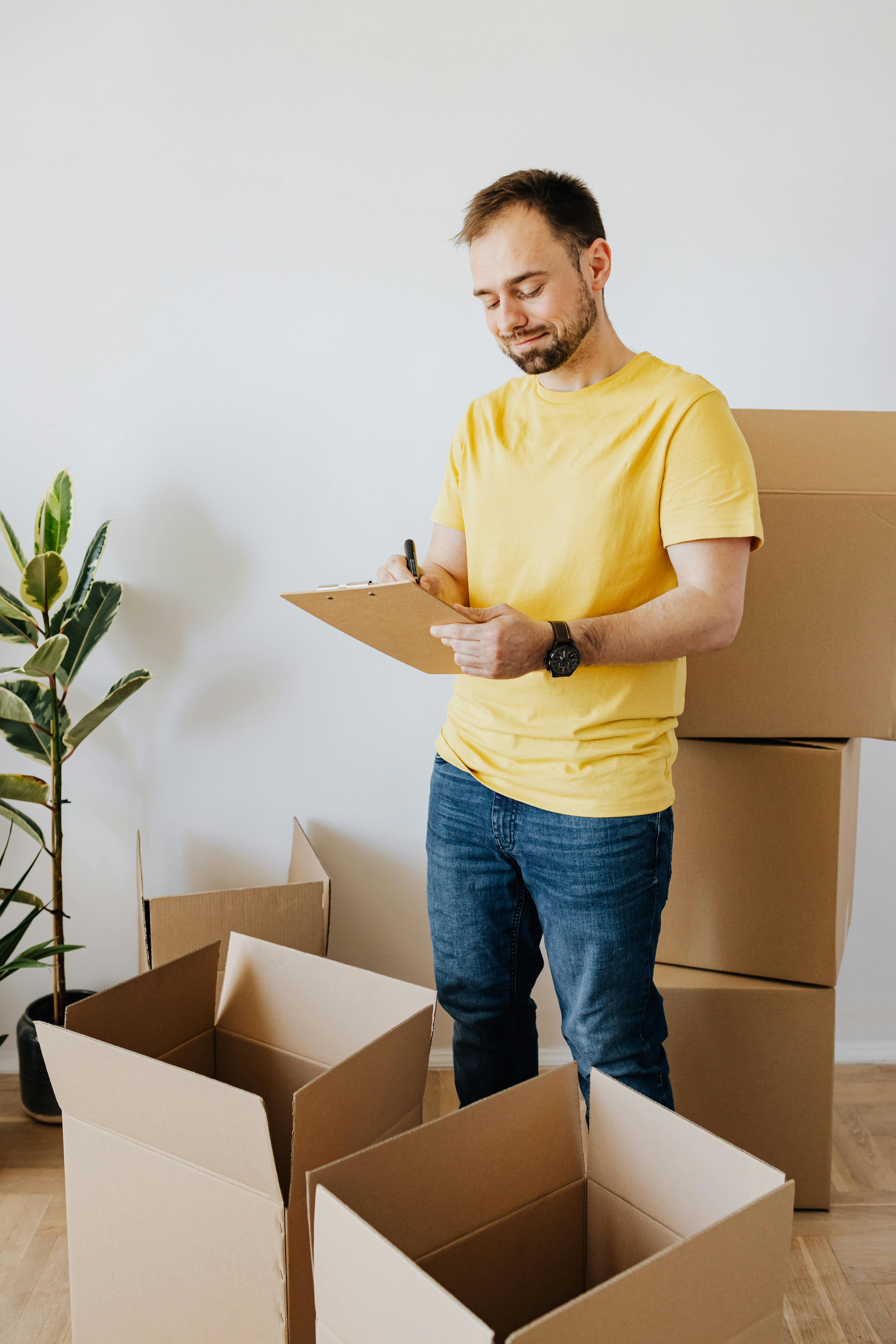 happy male taking notes with carton boxes