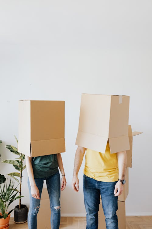 Free Unrecognizable couple carrying carton boxes on heads Stock Photo