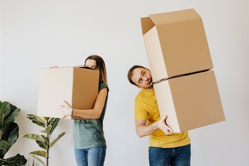 Free Cheerful couple carrying boxes with belongings Stock Photo