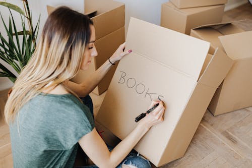 Free Content  woman writing on cardboard container word book Stock Photo