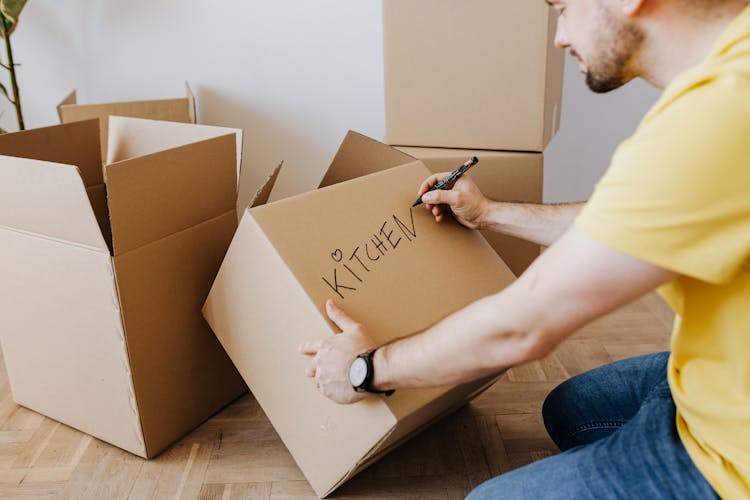 Crop Man With Pile Of Cardboard Boxes For Packing Belongings