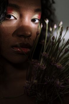 这幅戏剧性肖像以一位卷发、饰有花卉元素的女性为主体，并在引人注目的光线下呈现
