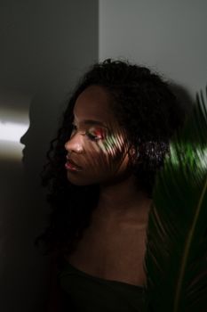一幅描绘卷发、脸上映着叶影的女人的艺术肖像