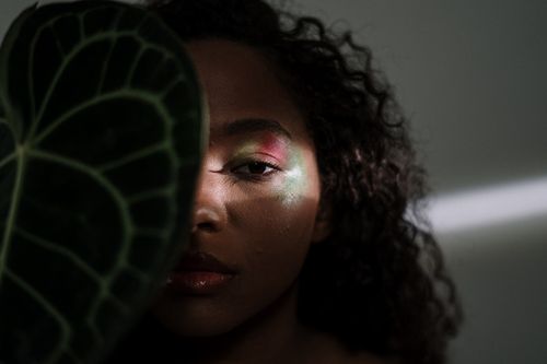 Free Striking portrait of a woman with shadow play and foliage in an artistic composition. Stock Photo