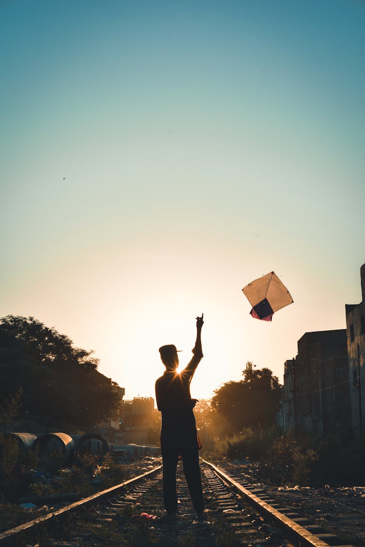 Silhouette Of A Person Flying  A Kite