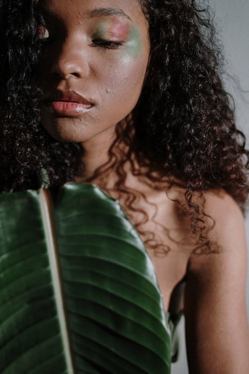 Natural woman holding a leaf to cover herself