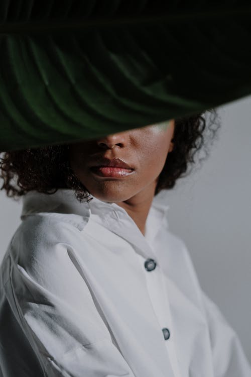 Woman in White Button Up Shirt Wearing Green and Black Hat