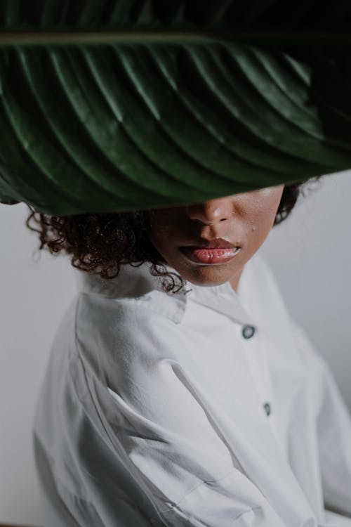 Woman in White Button Up Shirt With Green Hat