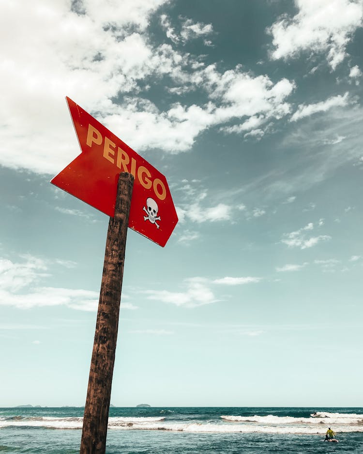 Sign Located Near Waving Sea Water