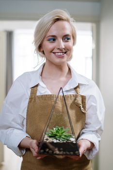 一位开朗的女人家里，有一个装有多肉植物的玻璃器皿