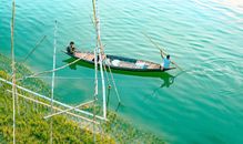 Ethnic men floating on canoe along pure blue lake