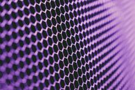 Abstract geometric texture of purple metallic net on dark background