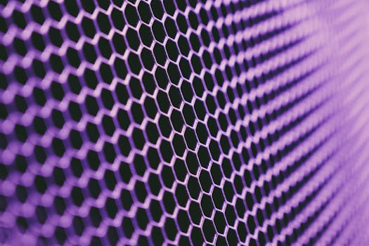 A close-up view of a vibrant purple hexagonal grid pattern, providing a modern metallic texture.