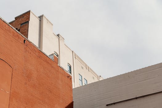 An architectural shot featuring brick and concrete building exteriors against a clear sky.