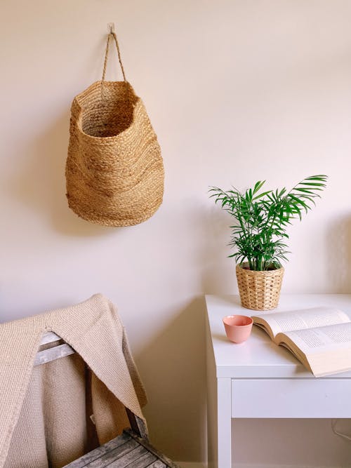 Free A Woven Basket Hanging on a Wall Near Potted Plant Stock Photo