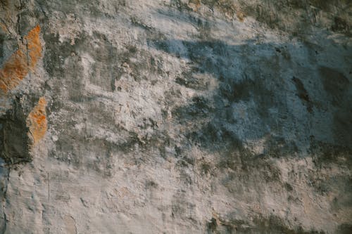 Abstract background of old grungy rough cement wall with uneven texture and cracks