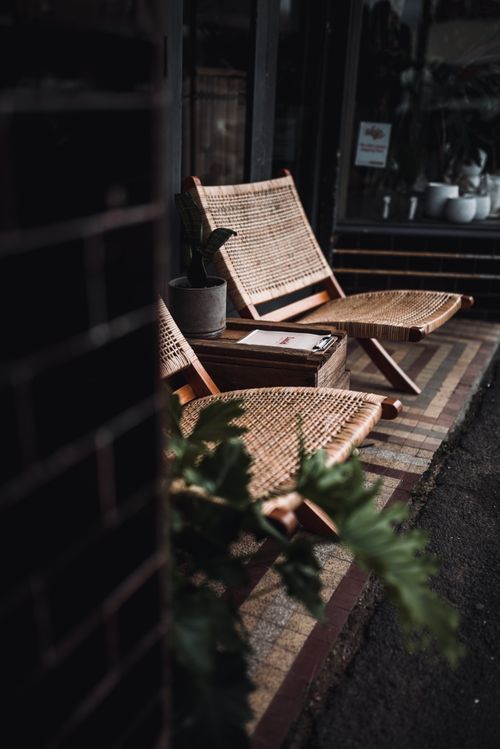 Free Two woven chairs and a potted plant create a cozy outdoor ambiance. Stock Photo