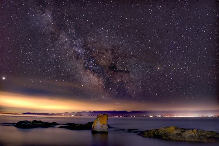 Starry Night Sky Over Body Of Water