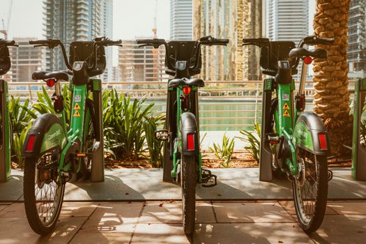 Careem bikes parked in Dubai Marina on a sunny day, showcasing modern urban transportation.