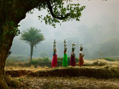 Four women carrying pots along a track — photo by Ganta Srinivas on Pexels