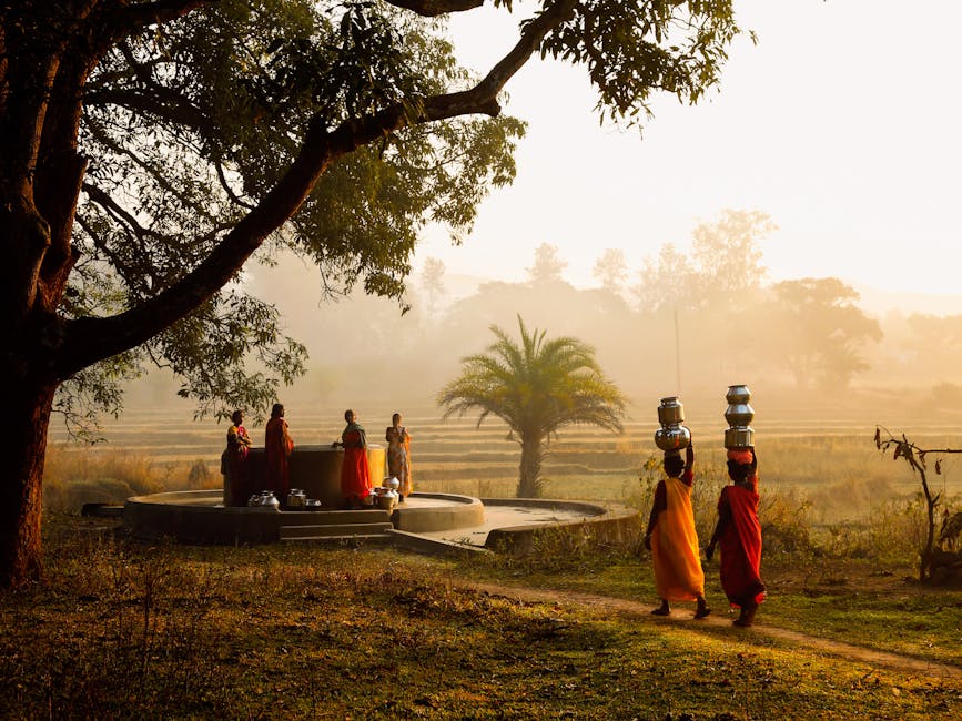 Women bearing water pots walk beside a well in the picturesque Araku Valley, India.