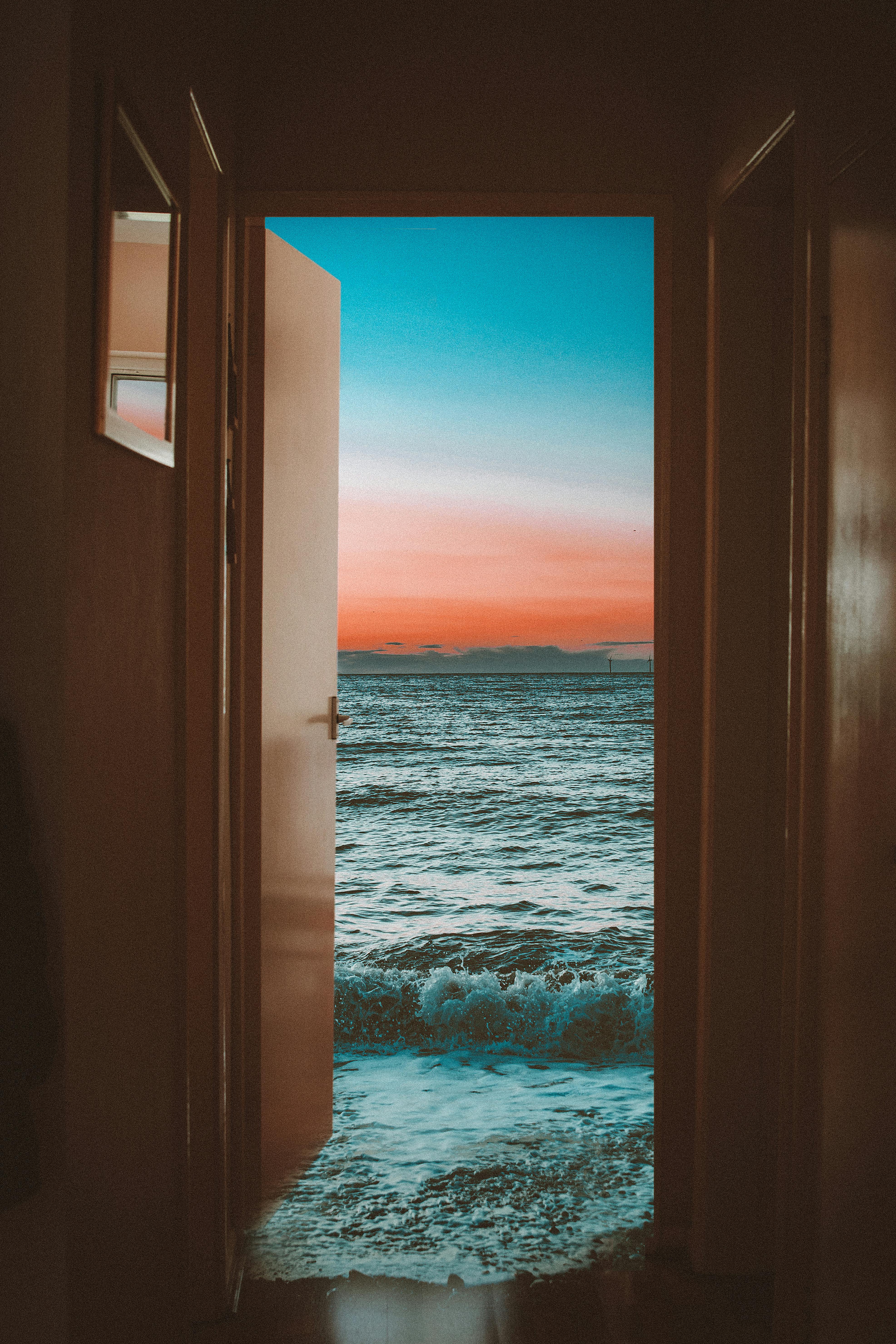 foamy sea waving near entrance of beach house