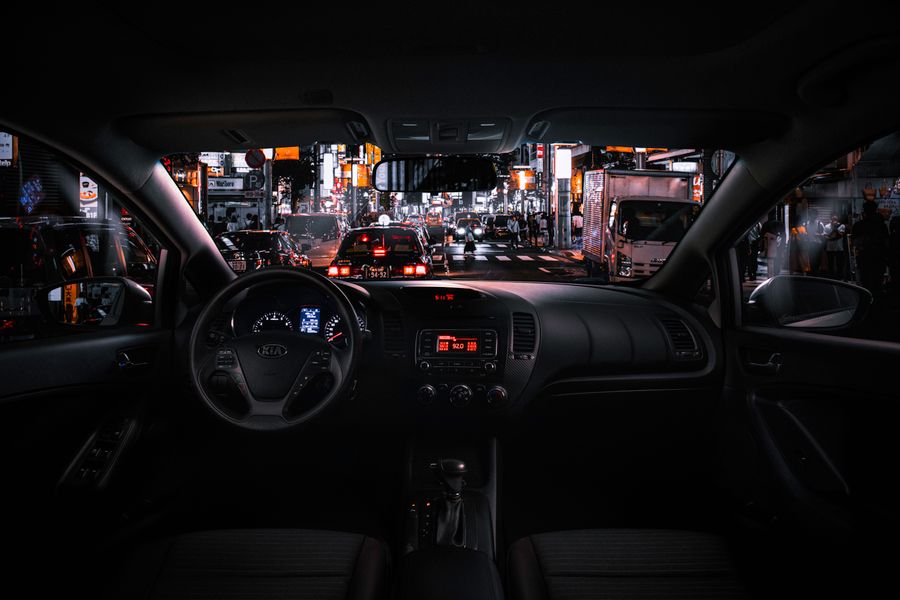 Car dashboard at night facing a neon-lit street — photo by Aleksandar Pasaric on Pexels