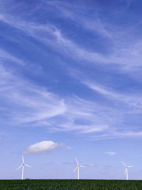 Free Wind turbines in Randers, Denmark against a vibrant blue sky with white clouds. Stock Photo