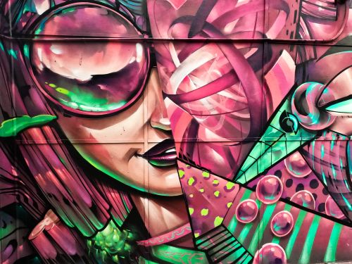 Free A vivid and colorful graffiti mural depicting abstract shapes and faces. Stock Photo