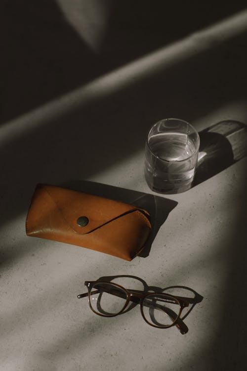 Brown Leather Pouch Beside Clear Drinking Glass