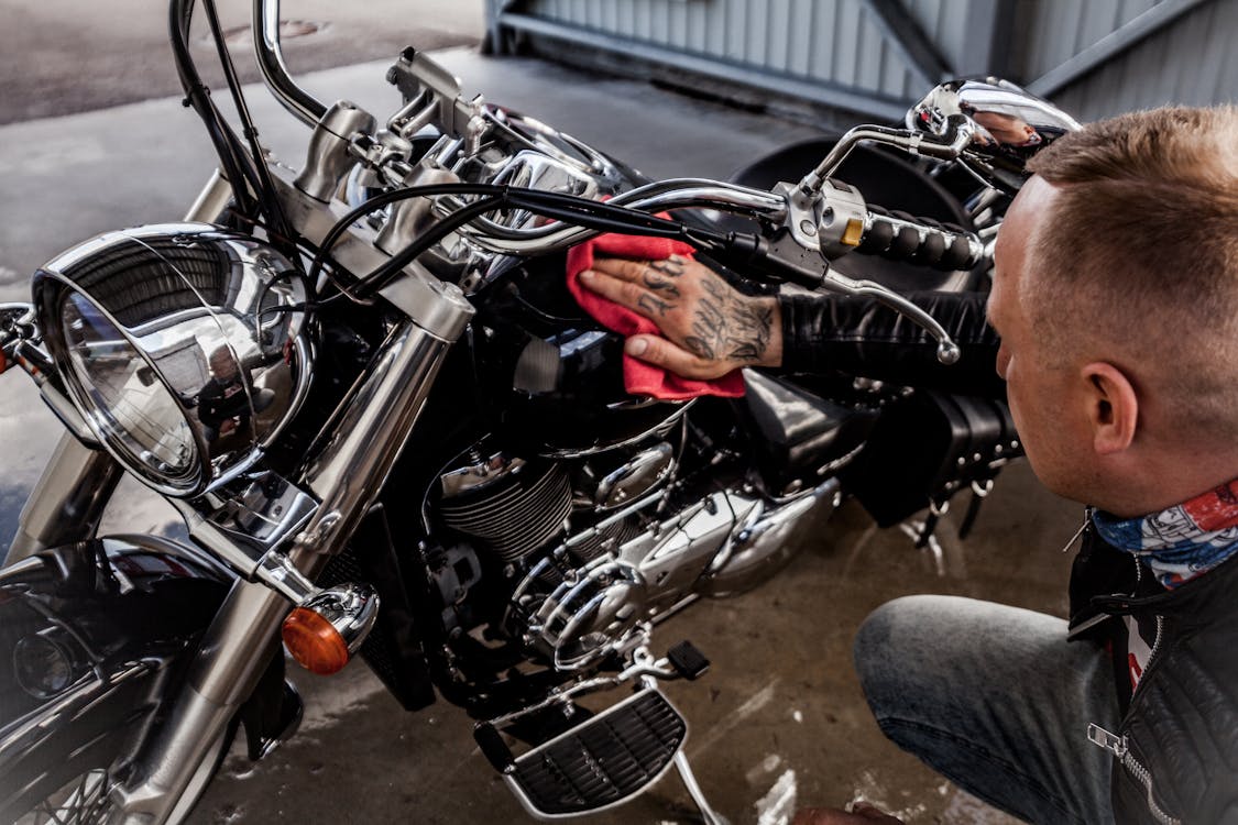 Photo of Man Wiping His Black Motorcycle