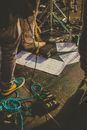 From above of crop faceless musicians standing on stage with various equipment and notes during rehearsal